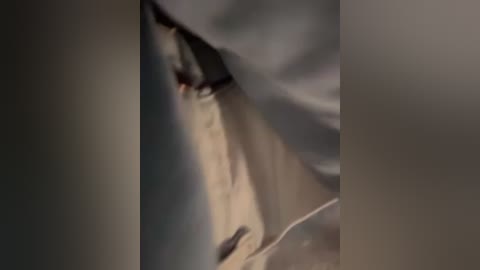 Media: A blurry video of a person's face partially covered by a beige blanket, with indistinct features and a muted color palette.