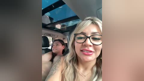 Media: Video of a blonde woman with glasses and a tattooed man in a limo, both smiling, with tinted windows and an open roof.