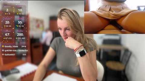 Media: A composite image with a blonde woman wearing a grey top and tan skirt, holding a phone, and a close-up of her exposed genitalia. Background shows a blurred office setting.