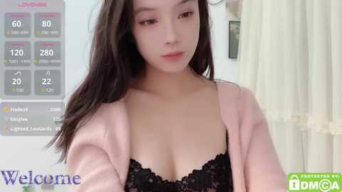 Media: Video of a young East Asian woman with long black hair, wearing a black lace bra under a pink cardigan, standing in a bright room with a white curtain and a digital scale in the background.