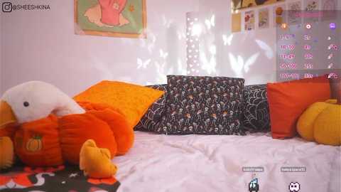 Media: A video of a cozy bedroom with plush toys, a white bed, and a digital screen displaying text and icons.