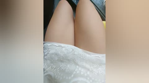 Media: Video of a person's legs, with smooth, light skin and pale blue shorts. The background is blurred, with a soft, warm color gradient.