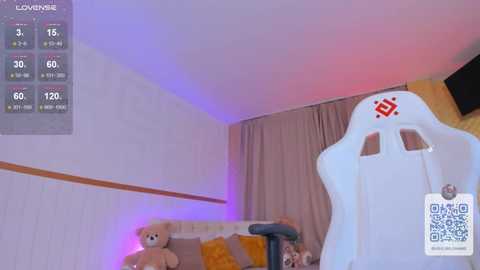 Media: Video of a cozy bedroom with a plush teddy bear, a white gaming chair, and a colorful LED strip lighting the room.