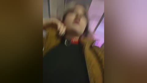 Media: A blurred video of a person with a dark jacket and red collar, possibly in a nightclub or dimly lit room, with indistinct background colors.