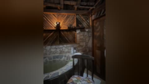 Media: Video of a rustic, dimly lit bathroom with a stone wall, wooden beams, and a small, round bathtub partially filled with green water. A wooden stool and a small, round mirror are visible.