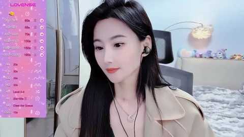 Media: Video of an East Asian woman with long black hair, wearing a beige jacket, black earrings, and headphones, sitting indoors with a pink, starry background and a list of options on the left.