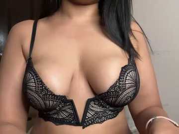 Media: Video of a woman with medium brown skin wearing a black lace bra, revealing ample cleavage. Her straight, black hair cascades over her shoulders.