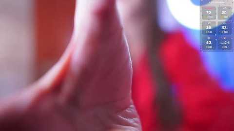 Media: A close-up video of a hand with a red nail polish, blurred background, and a digital clock displaying 7:26 PM, 72\u00b0F, 40% humidity, and 32% chance of rain.