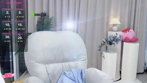 Media: Video of a white, plush armchair in a modern living room with gray curtains, a pink lamp, and a plush toy, with a digital overlay showing statistics and a lens flare.