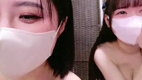 Media: A close-up video of an Asian woman with straight black hair, wearing a white mask, showing her brown eyes and pale skin.