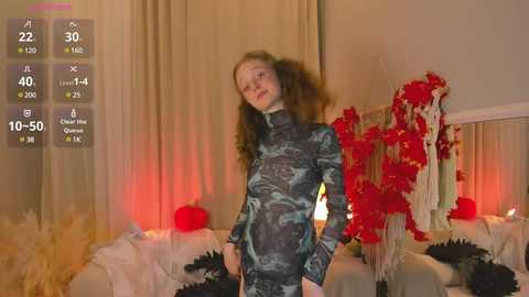 Media: Video of a young woman with curly red hair in a camo-patterned dress, standing in a dimly lit room with red and white decorations.