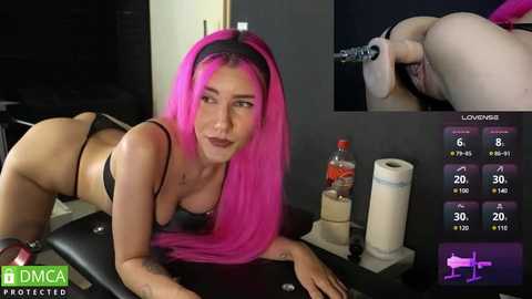 Media: Video of a pink-haired woman in black lingerie, on all fours, in a BDSM-themed room.