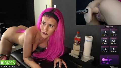 Media: A video of a nude woman with pink hair, lying on a table, wearing a headset, in a medical setting.