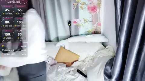 Media: Video of a disheveled bedroom with a white bed, a stuffed animal, a black remote, and a wall-mounted air purifier. A digital display shows temperature and humidity levels.