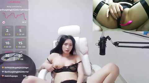 Media: A video of an Asian woman with long black hair, wearing lingerie, seated on a white chair, masturbating with a pink vibrator.