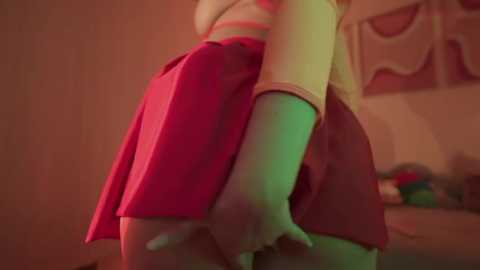 Media: Video of a young woman with light skin, wearing a red skirt and green shirt, bending over, displaying her buttocks.