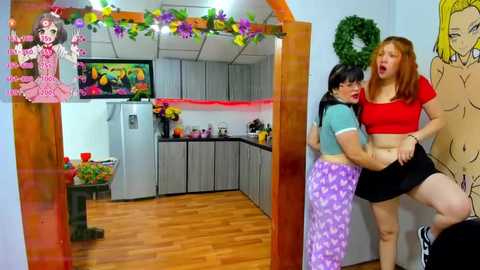 Media: Video of a bright kitchen with two young women, one in a red crop top, the other in purple pajamas, engaged in playful physical contact.