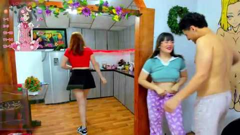 Media: Video of a young woman in a red crop top and black skirt, looking back, in a colorful, cartoon-decorated kitchen. A shirtless man in white pajama pants and a woman in a blue shirt and purple pajamas stand beside her.