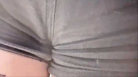 Media: A close-up video of a person's lower body in a gray, wrinkled pair of jeans, emphasizing the fabric's texture and folds.