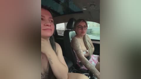 Media: Video of two shirtless people in a car, a young man with a tattoo on his arm and a woman with glasses and a floral skirt.