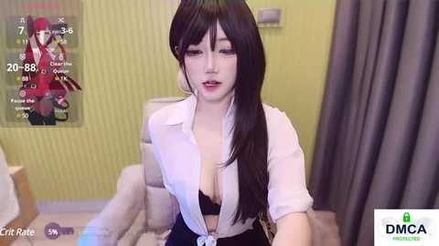 Media: Video of a young woman with long black hair, wearing a white blouse and black bra, sitting in a modern office with a green wall and a chair.