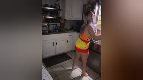 Media: A video of a woman with long, lavender hair in a red and yellow Mario-themed tank top, cooking in a dimly lit kitchen.