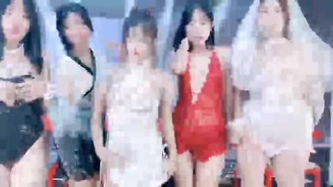 Media: This is a blurred, low-resolution video of four women in lingerie, including a red lace bodysuit and white dresses, standing together indoors.