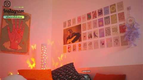 Media: Video of a cozy room with an orange couch, butterfly lights, a large wall of tarot cards, and a colorful abstract print on the wall.