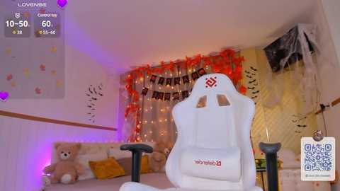 Media: Video of a cozy, themed bedroom with a white gaming chair, teddy bear, and fairy lights. Background includes Halloween decorations and a QR code.