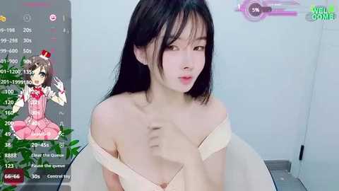 Media: A digital photo of an East Asian woman with long black hair, fair skin, and a slim physique, wearing a beige off-shoulder dress. The image includes a live-stream overlay showing her face superimposed on a video game character.