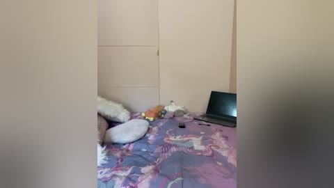 Media: A video of a cluttered bedroom with a beige wall, a closed door, a purple-patterned bedspread, a plush toy, a stuffed animal, and a black computer monitor.