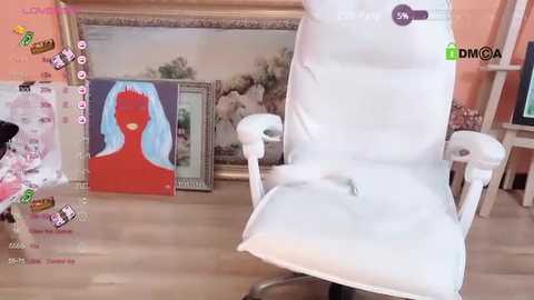 Media: Video of a white recliner chair with a light blue headrest, surrounded by colorful, modern art prints and a wooden floor.