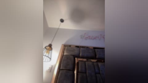 Media: A blurry video of a bedroom ceiling with a metallic ceiling fan, a light fixture, and a partially visible \"sleep\" sign on a white wall.