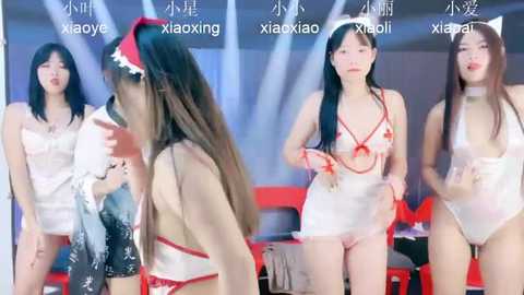 Media: Video of four Asian women in revealing Christmas-themed lingerie, each labeled \"xiangying.\" Background includes blurred red and white decor.