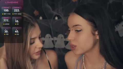 Media: Video of two young women with long hair, one in a black dress, the other in a silver dress, smoking cigarettes, with a digital overlay displaying stats like \"100%,\" \"ZZZ,\" and \"777.\