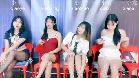 Media: Video of four Asian women with long black hair, seated on red plastic chairs, wearing revealing outfits, against a backdrop with \"Xiiaoxiao\" branding.