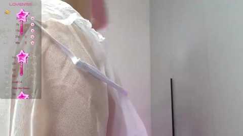 Media: A close-up video of a white person's back, covered in a pink, translucent, textured plastic wrap, with a long, silver tube attached, suggesting a medical procedure. The background is blurred.