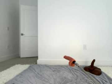 Media: A video of a minimalist, white-walled room with a gray blanket, a wooden chair, and a white door in the background.