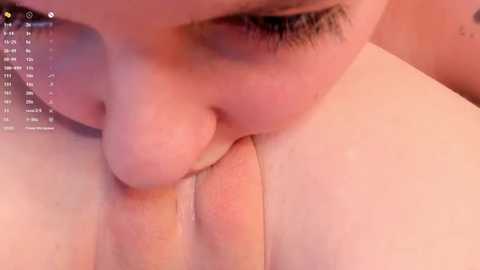 Media: Close-up video of a Caucasian woman with fair skin, large brown eyes, and long lashes, performing oral sex on a circumcised penis, which is partially erect. The background is out of focus.