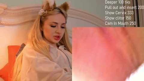 Media: A video of a young woman with long blonde hair, wearing a white robe and cat ears, in a bedroom. Text overlays show details of her video.