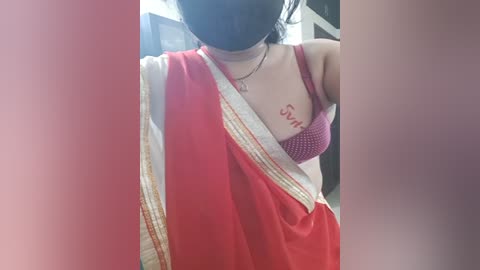 Media: A video of a woman with a red sari, black mask, and a red bra visible, showing a tattoo of the word \"Soul\" on her chest.