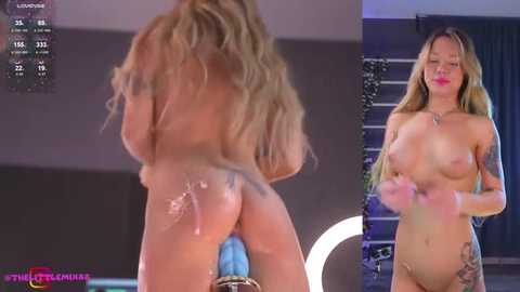 Media: Video of a naked, tan-skinned woman with long blonde hair, medium-sized breasts, and tattoos, standing in a modern room with a round mirror and blue furniture.