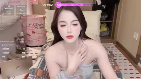 Media: Video of a young Asian woman with long black hair, fair skin, and red lipstick, lying on a patterned rug in a cozy room, surrounded by a digital overlay with social media elements.