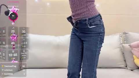 Media: A video of a person in blue jeans and a knit sweater standing in a modern living room with a white sofa and beige walls. The image is overlaid with a virtual reality interface showing statistics and a pink star.