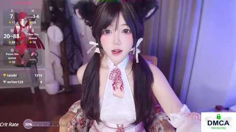 Media: Video of an Asian woman with long black hair in twin ponytails, wearing a red and white bunny costume, sitting in a living room.