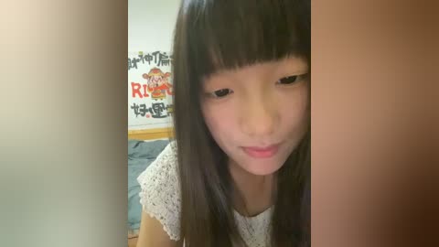 Media: Video of an Asian girl with long black hair and bangs, wearing a white lace top, smiling gently. Background features a wall with a colorful Japanese poster and a bed with blue bedding.