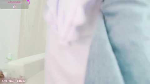 Media: A blurred photo of a person wearing a light-colored shirt and a light-colored jacket, possibly in a bathroom. The background shows a white bathtub with a faint pink towel. The timestamp reads \"15:30.\