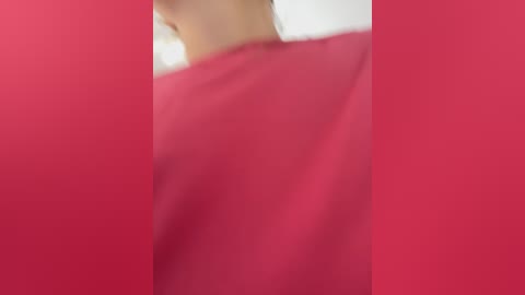 Media: A video of a person wearing a bright red shirt, with the focus blurred and the background mostly out of focus, creating a soft, dreamy effect.