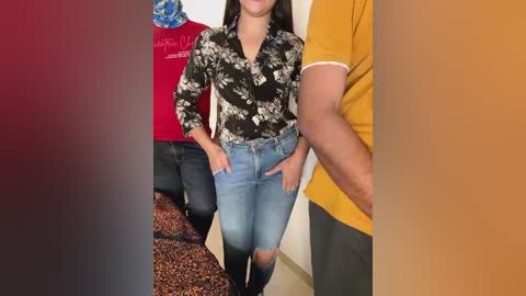 Media: Video of three people indoors: a woman in a floral blouse, blue jeans, and black boots, a man in a red shirt, and another in a yellow shirt.