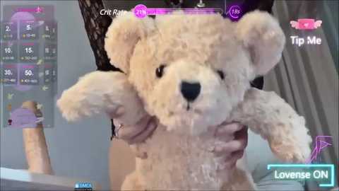 Media: A video of a person holding a white teddy bear, with a virtual city skyline and health bars displayed on the screen, suggesting a gaming context.